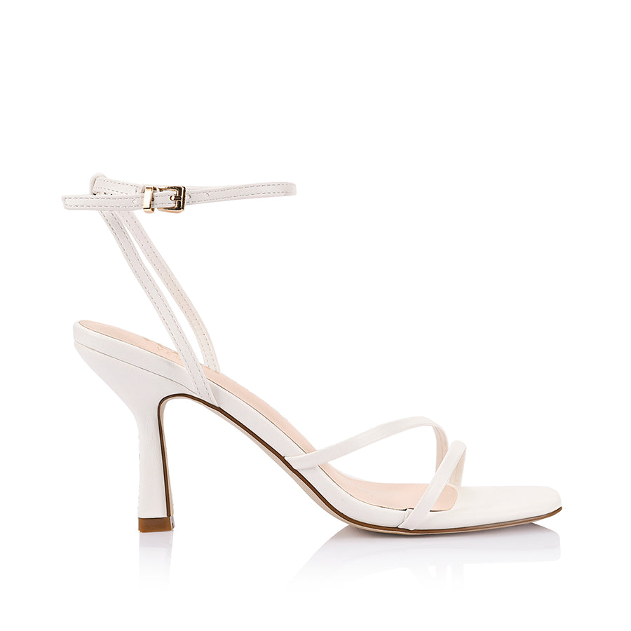 White high-heeled sandal with thin straps and gold buckles